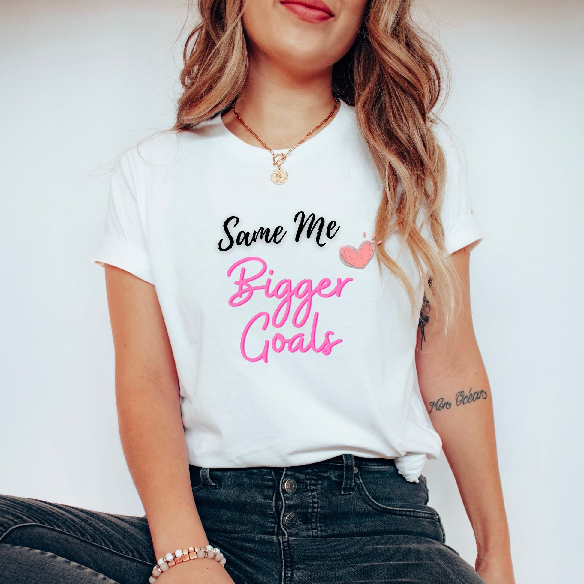 A stylish woman wearing a white t-shirt with a slogan that says - "Same Me, Bigger Goals"